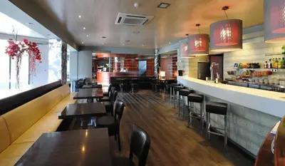 a restaurant with tables and chairs and a bar at Hotel Els Noguers in Manresa