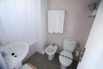 a bathroom with a white toilet and a sink at Solvi Hotel - Adults Only in Vilanova i la Geltrú