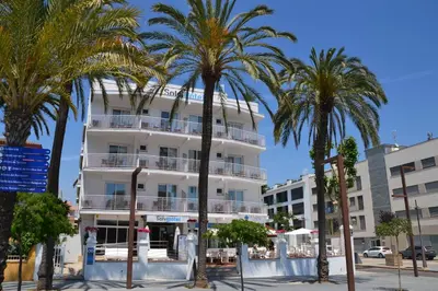 a white building with palm trees in front of it at Solvi Hotel - Adults Only in Vilanova i la Geltrú