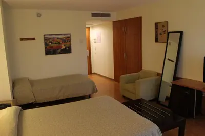 a living room with a bed and a couch and a chair at Hotel Flora Parc in Castelldefels