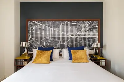 a bedroom with a large bed with blue and gold pillows at Naitly Barcelona Poblenou in Barcelona