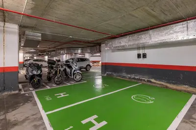 a parking garage with motorcycles parked in it at Naitly Barcelona Poblenou in Barcelona