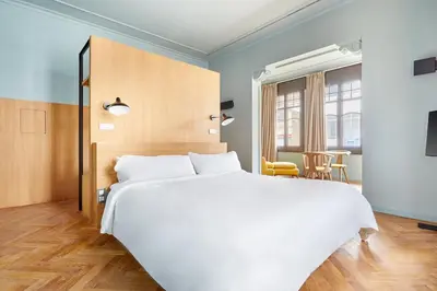 a bedroom with a large white bed and a table at Le Palacete by Sweett in Barcelona