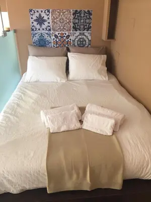 a bed with two white towels on top of it at Sitges Studio in Sitges