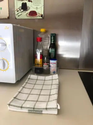 a counter with bottles of alcohol and a microwave at Sitges Studio in Sitges