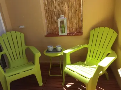 two green chairs and a table with cups on it at Sitges Studio in Sitges