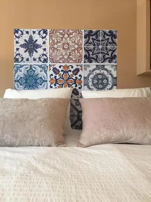 a bed with blue and white tiles on the wall at Sitges Studio in Sitges
