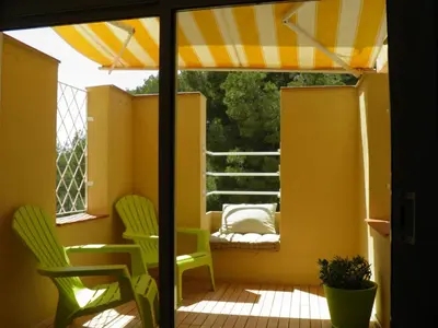 a patio with two chairs and an umbrella at Sitges Studio in Sitges