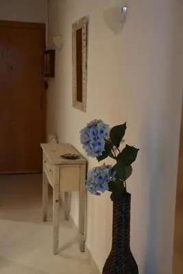a vase with blue flowers sitting next to a table at Apartamento Flavia I Espalter in Sitges