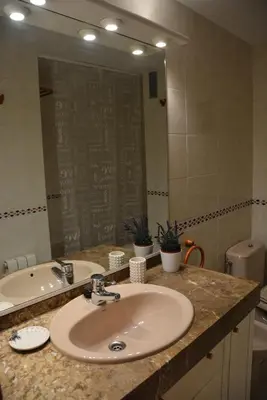 a bathroom with a sink and a large mirror at Apartamento Flavia I Espalter in Sitges