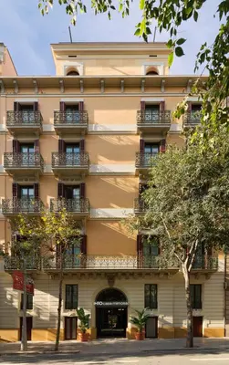 an apartment building with balconies and trees at H10 Casa Mimosa 4* Sup in Barcelona