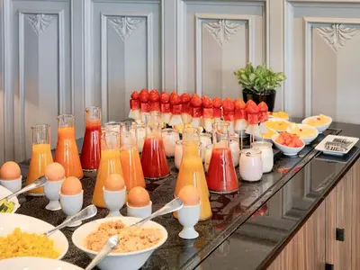 a buffet with eggs and drinks and bowls of food at H10 Casa Mimosa 4* Sup in Barcelona