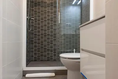 a bathroom with a toilet and a glass shower at Flateli Roger 6 in Barcelona