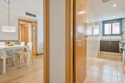 a kitchen and dining room with a white table and a table and chairs at Inside Barcelona Apartments Princep in Barcelona