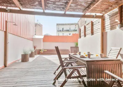 an outdoor patio with a wooden table and chairs at Inside Barcelona Apartments Princep in Barcelona