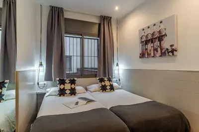 a hotel room with two beds and a window at AB Sagrada Familia - Gaudí in Barcelona