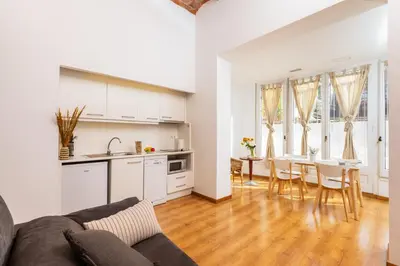 a kitchen and living room with a couch and a table at Mayerling Schumann Barcelona in Barcelona