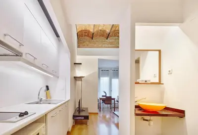 a kitchen with white cabinets and a yellow bowl on a counter at Mayerling Schumann Barcelona in Barcelona