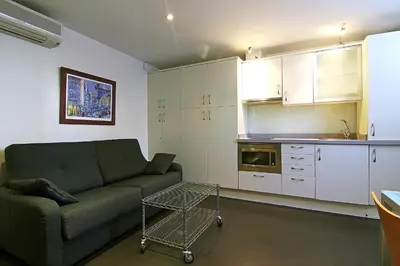 a living room with a couch and a kitchen at Classbedroom Born Apartments in Barcelona