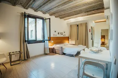 a bedroom with two beds and a table in a room at Ramblas Apartments in Barcelona