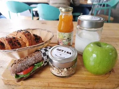 a sandwich and an apple on a cutting board at Ramblas Apartments in Barcelona