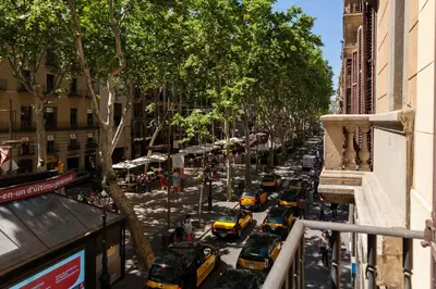 a city street filled with lots of taxis at Ramblas Apartments in Barcelona