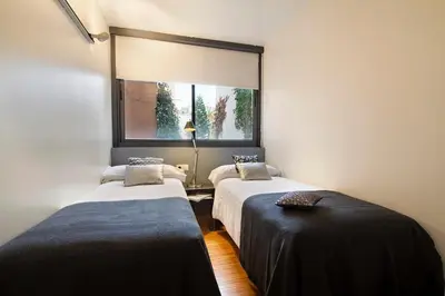 two beds in a room with a window at Apartment Barcelona Rentals - Park Güell Apartments in Barcelona