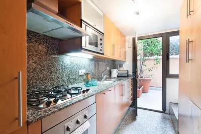 a kitchen with wooden cabinets and a stove top oven at Apartment Barcelona Rentals - Park Güell Apartments in Barcelona