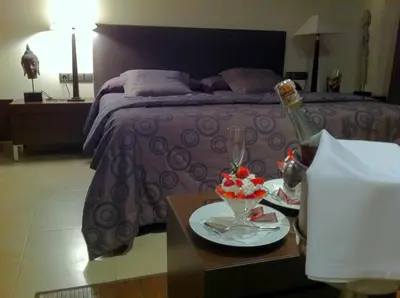 a bedroom with a bed and a table with a bottle of wine at Hotel Calabria in La Garriga