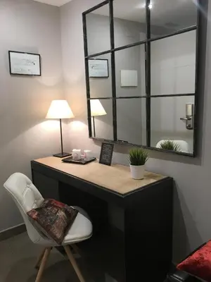 a desk with a white chair and a mirror at Hotel Calabria in La Garriga