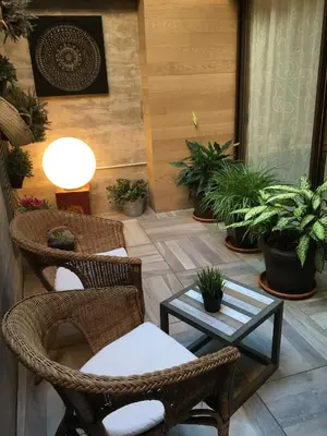 a patio with chairs and a table and potted plants at Hotel Calabria in La Garriga