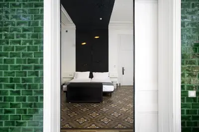 a room with a bed and a green brick wall at Praktik Rambla in Barcelona