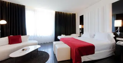 a hotel room with a bed and a couch at Hotel Porta Fira 4* Sup in Hospitalet de Llobregat