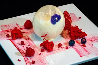 a white plate with an ice cream and strawberries at Hotel Porta Fira 4* Sup in Hospitalet de Llobregat