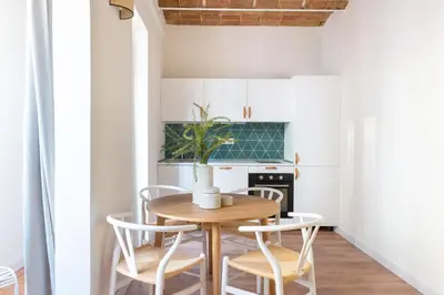 a kitchen with a wooden table and chairs at Diagonal Apartments by Olala Homes in Barcelona