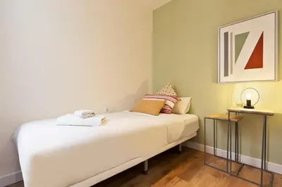 a bedroom with a white bed with two tables at Diagonal Apartments by Olala Homes in Barcelona