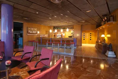 a lobby with chairs and a bar in the background at Hotel Domo in Vilafranca del Penedès