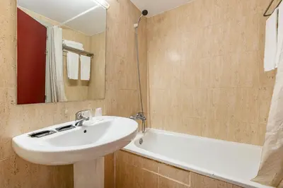 a bathroom with a sink and a bath tub at Hotel Basic in Vilafranca del Penedès