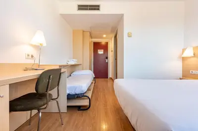 a hotel room with a bed and a desk and a chair at Hotel Basic in Vilafranca del Penedès