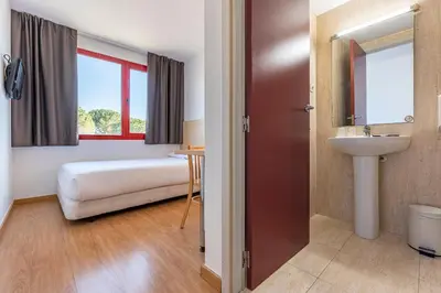 a bathroom with a bed and a sink in a room at Hotel Basic in Vilafranca del Penedès