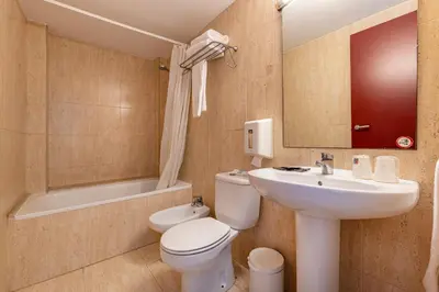 a bathroom with a sink and a toilet and a tub at Hotel Basic in Vilafranca del Penedès