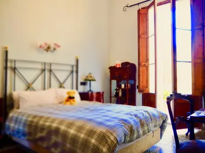a dog sitting on a bed in a bedroom at Privat Hotel Liberty Sitges in Sitges