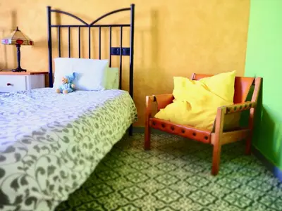 a bedroom with a bed and a chair at Privat Hotel Liberty Sitges in Sitges