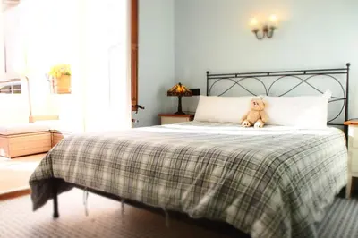 a teddy bear sitting on top of a bed at Privat Hotel Liberty Sitges in Sitges