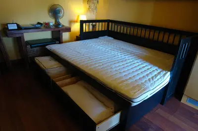 a large wooden bed in a room with a table at Sitges Beach Loft in Sitges