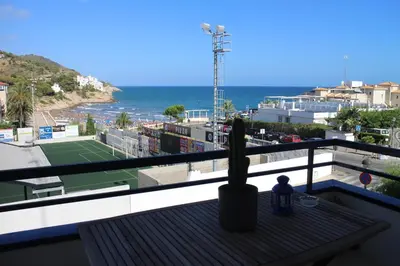 a person sitting on a balcony with a tennis court at Sitges Beach Loft in Sitges
