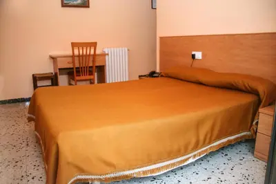 a bedroom with a bed with a desk and a chair at Raco d'en Pepe in Calella