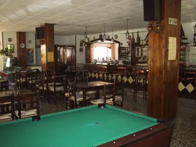 a pool table in a room with tables and chairs at Raco d'en Pepe in Calella