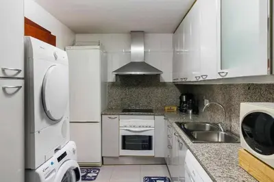a small kitchen with white cabinets and a sink at Comfortable 4 rooms 2Bath w balcony in Barcelona