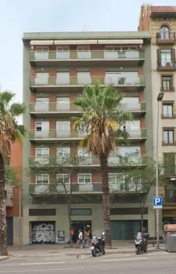 a tall building with a palm tree in front of it at Comfortable 4 rooms 2Bath w balcony in Barcelona